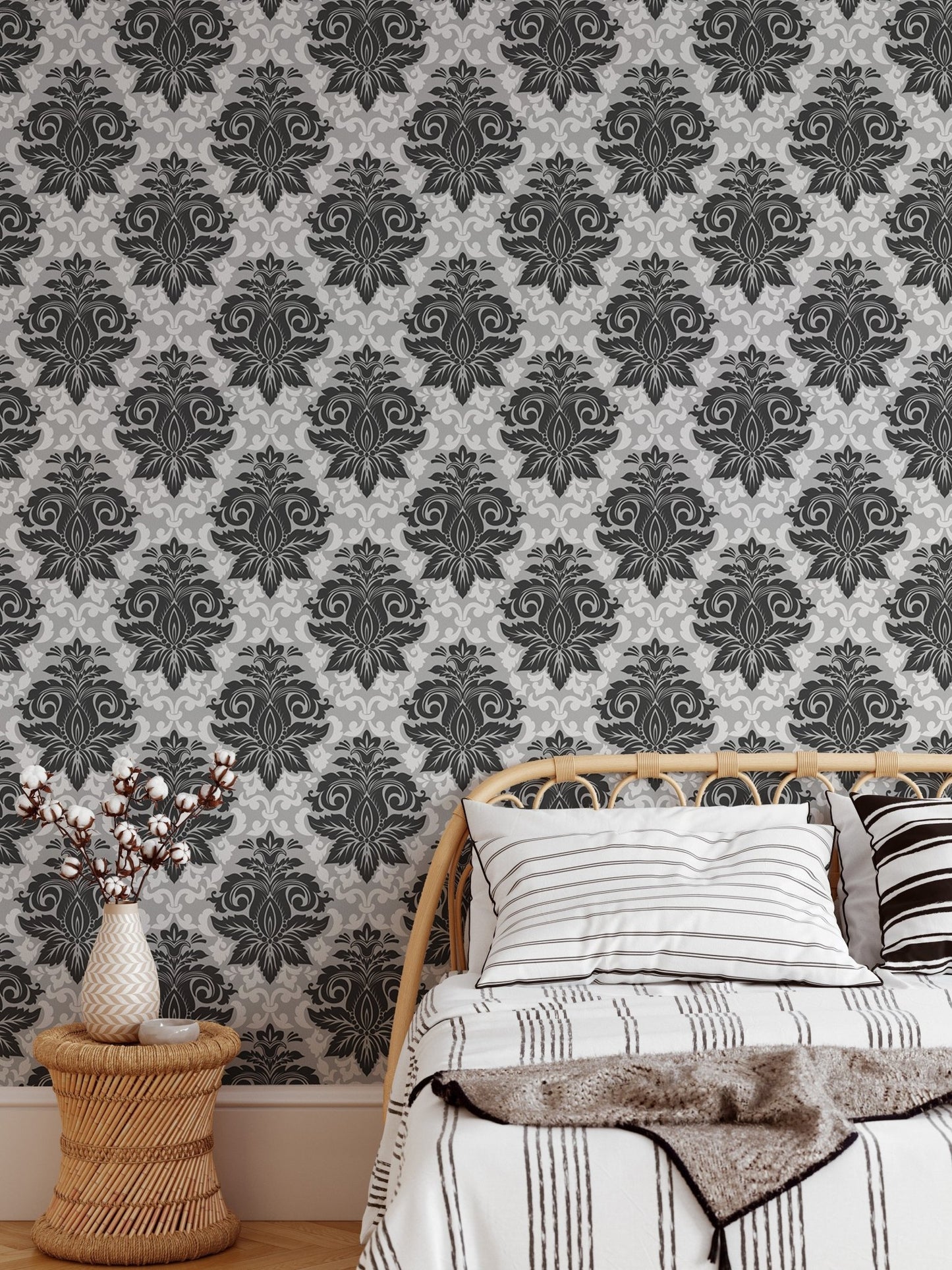 Intricate damask wallpaper in a bedroom featuring a wooden side table and vase.