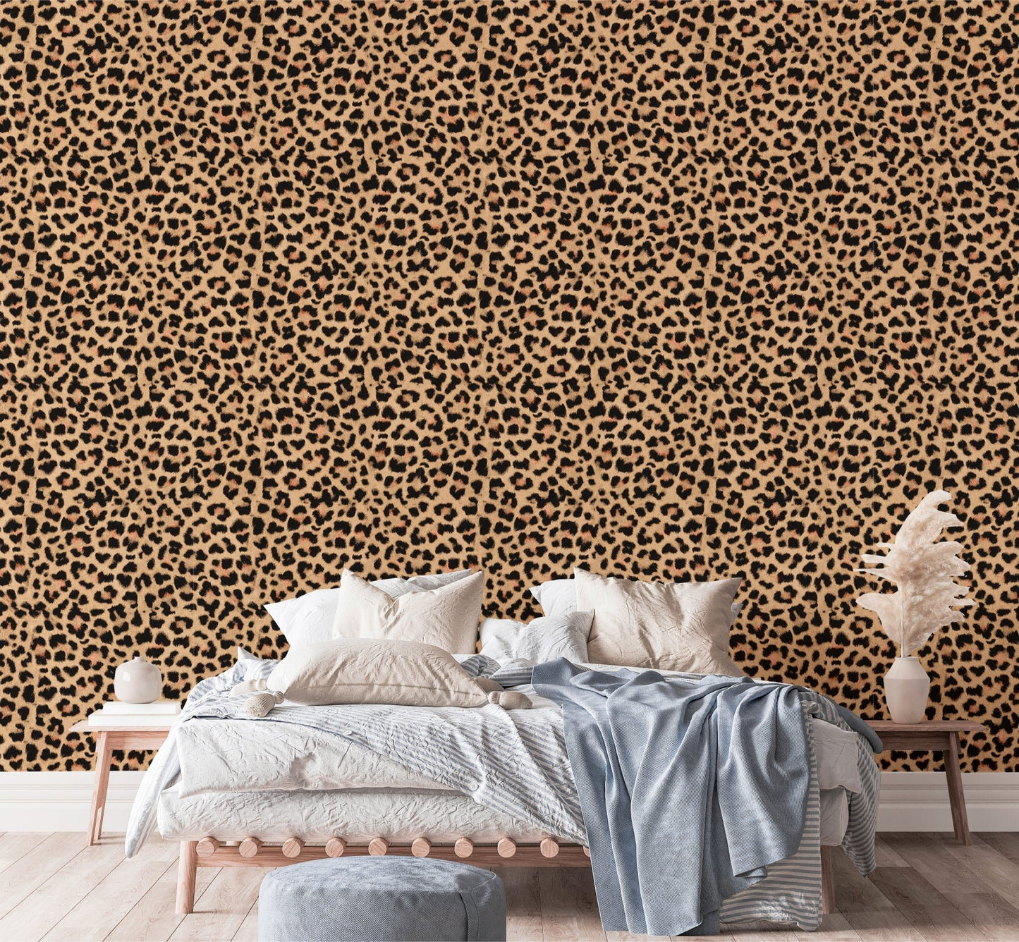 Brown leopard skin texture wallpaper behind a bed with blue and white linens in bedroom.