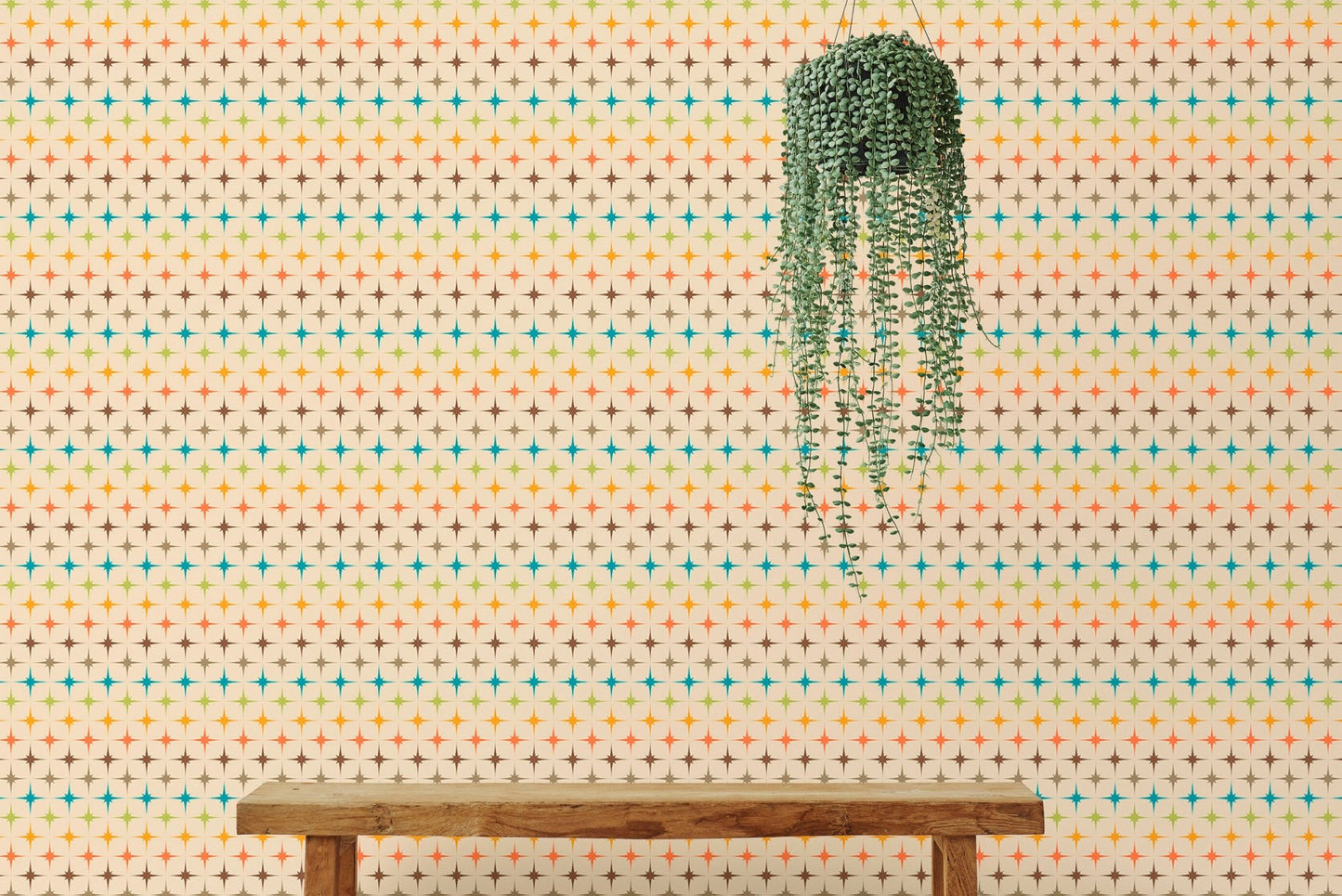Wall mural with orange and teal atomic patterns behind a wooden bench and plant.