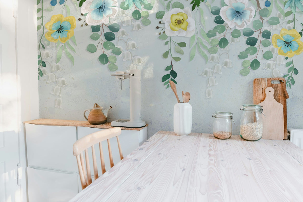 Wooden kitchen table set against a leafy botanical blossoms wall mural.