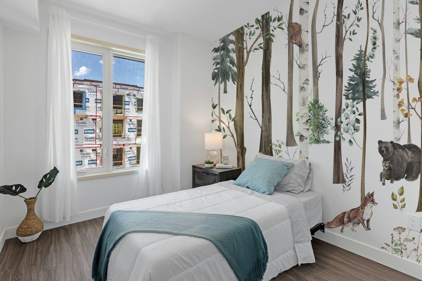 Bright bedroom with a woodland forest wall mural.