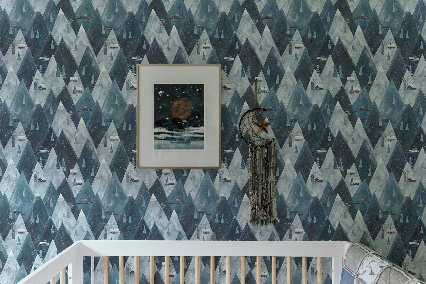 Scandinavian wallpaper with mountain and house pattern in nursery with white crib.