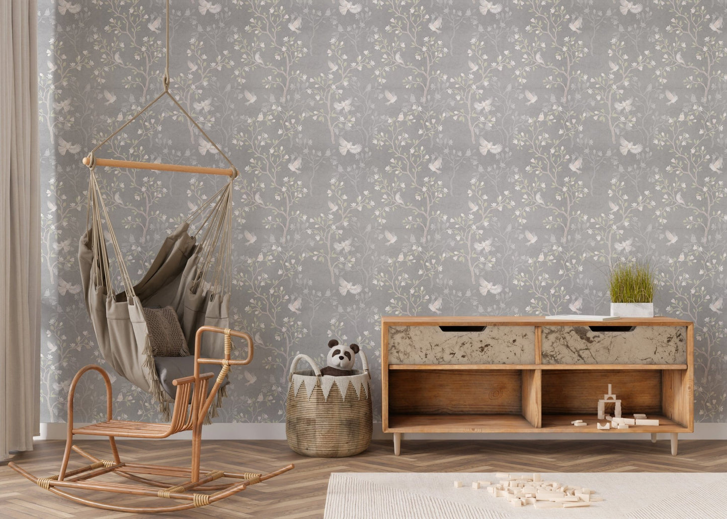 Chinoiserie wallpaper with white blossoms in a nursery room with a wicker pendant light.