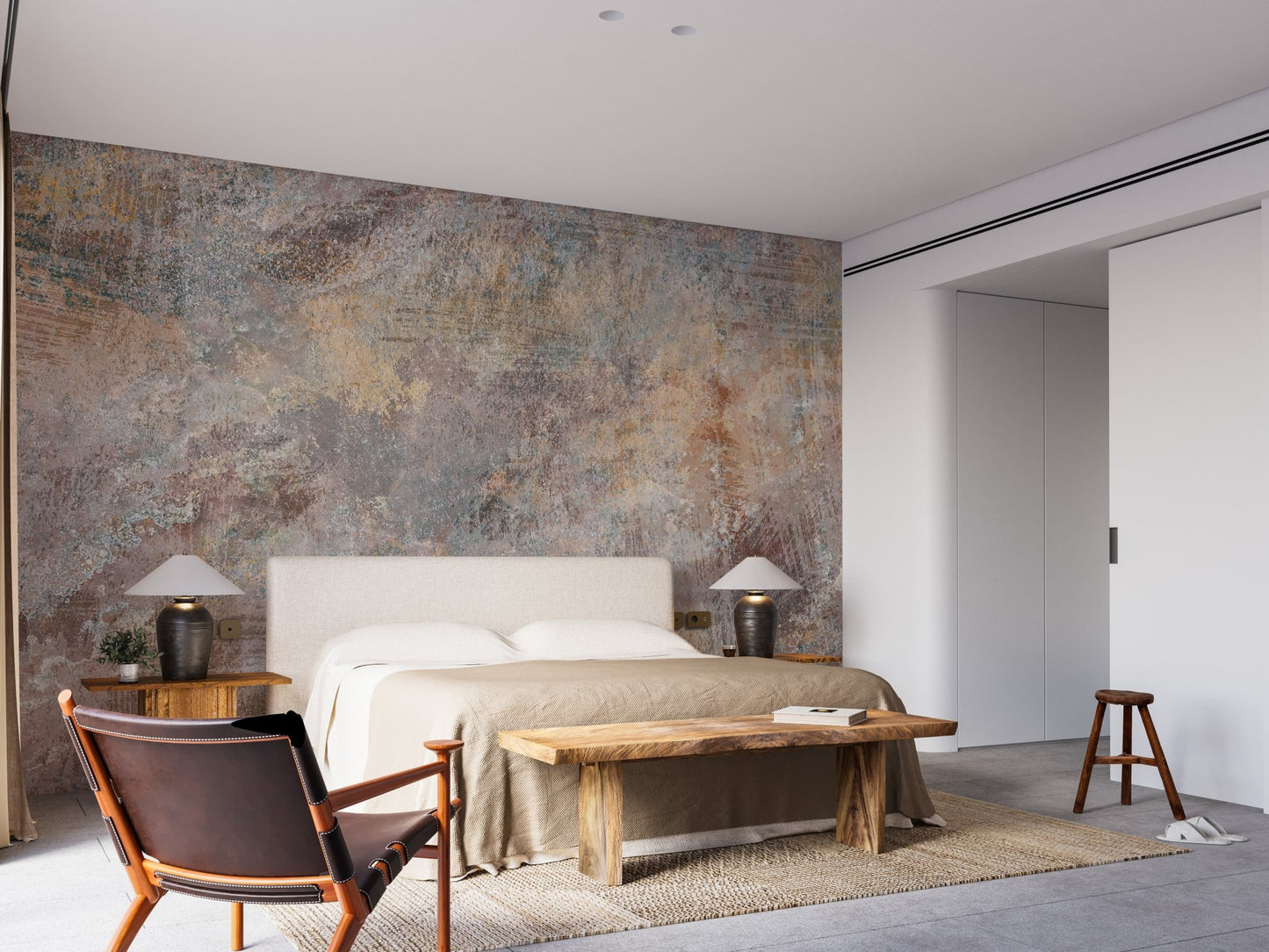 Large bedroom feature wall mural with a grey stone pattern and brown leather chair.