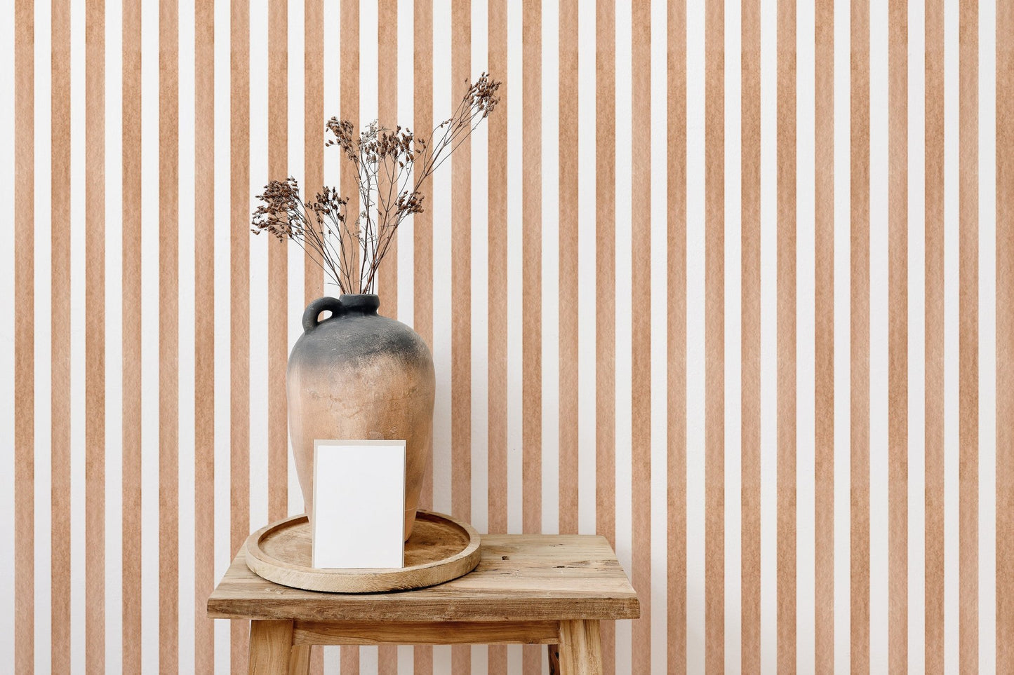 Striped watercolor wallpaper behind wooden table and vase