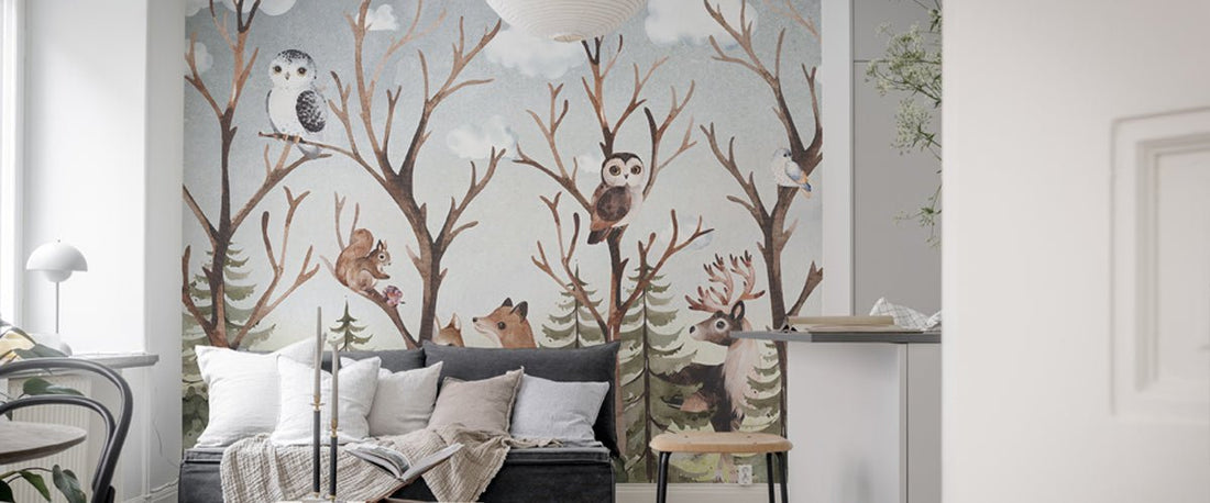 Woodland animals wall mural showing owls, a fox, and a stag among bare winter trees in a bright living room.