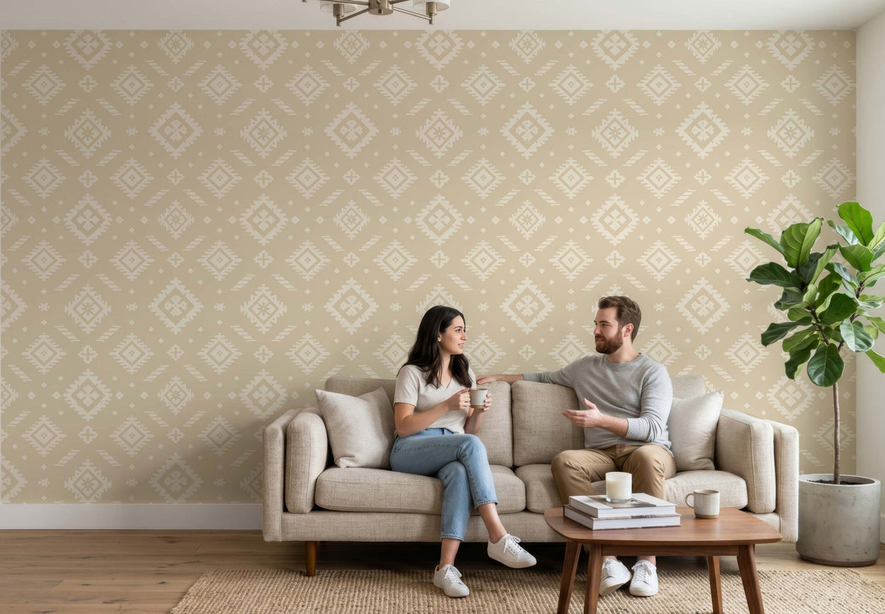 Man and woman sitting on a couch in a living room with patterned wallpaper.