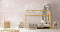 Pink cloud mural on toddler room walls with painterly cloud pattern. 