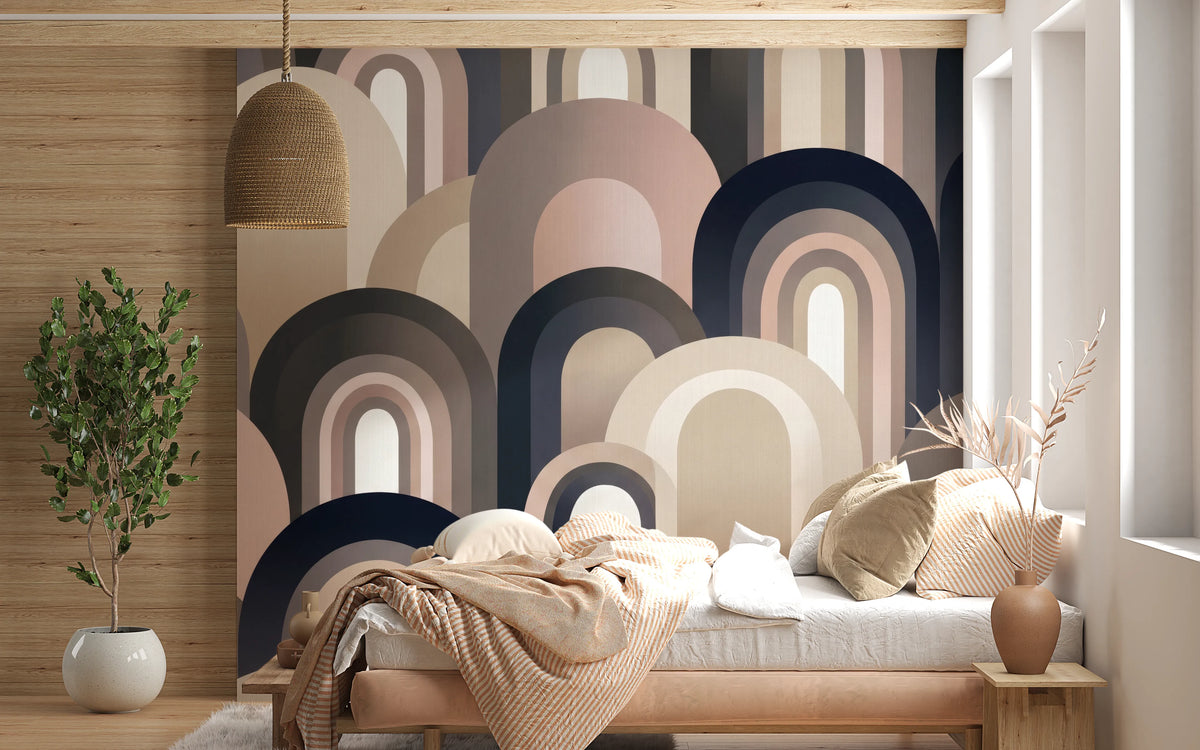 Curved geometric wall mural mixing soft pink, sand and charcoal blue bands in bedroom