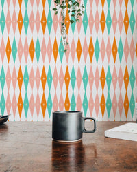 Workspace setup with a coffee mug and teal geometric bundle wall mural background.