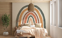 Soft boho rainbow mural creating a cozy nursery atmosphere.
