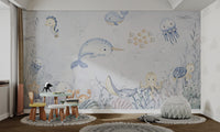 Happy narwhal swimming with fish and jellyfish in an underwater adventure mural.