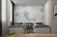 Little explorers in space floating with rockets, planets, and stars among clouds.