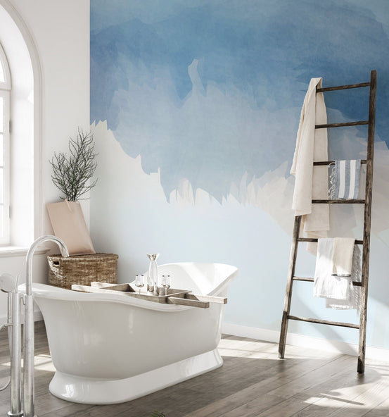 Watery blue palette wall mural in a bright bathroom with a wooden ladder towel rack.