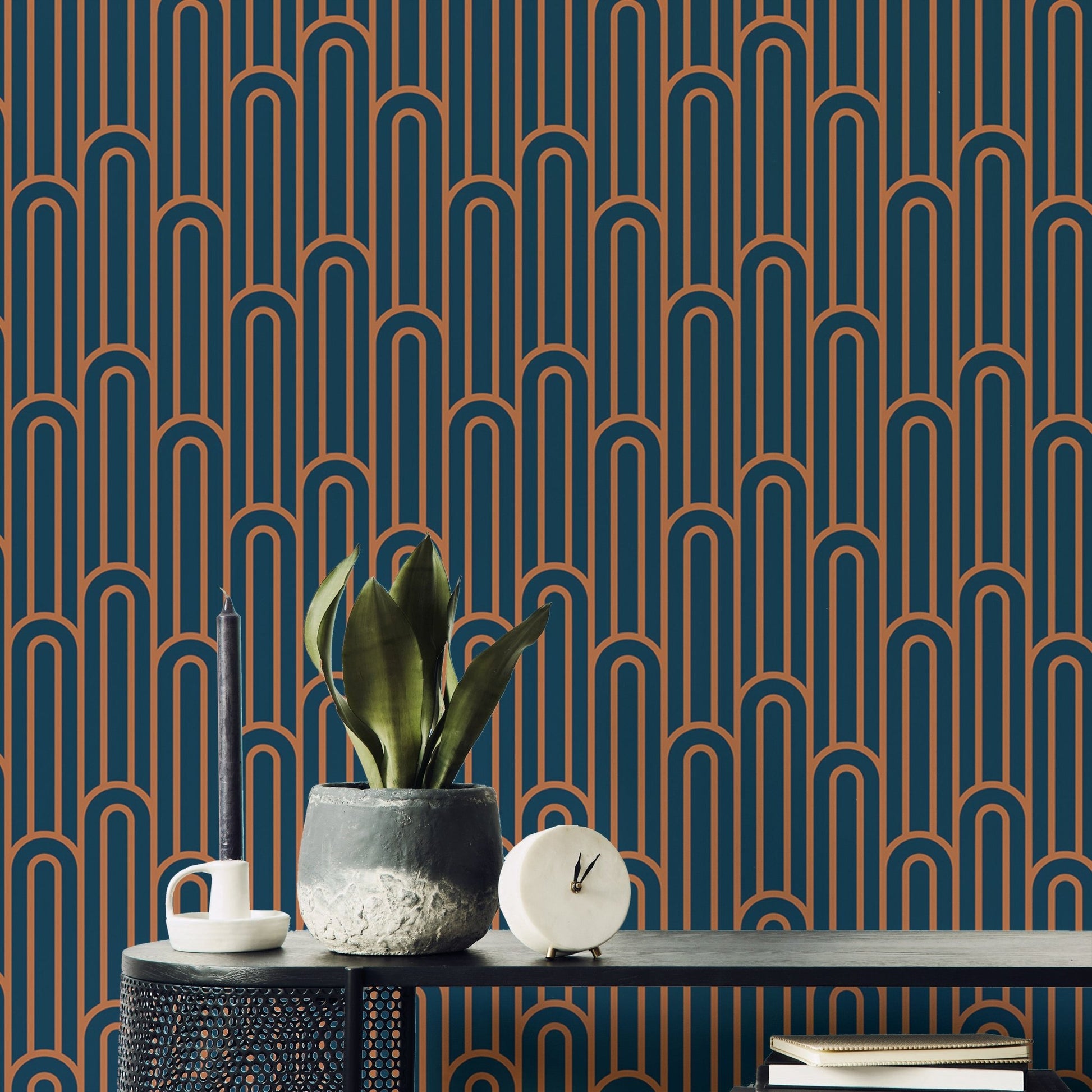 Art Deco arch pattern wallpaper in a workspace with a desk and plant.