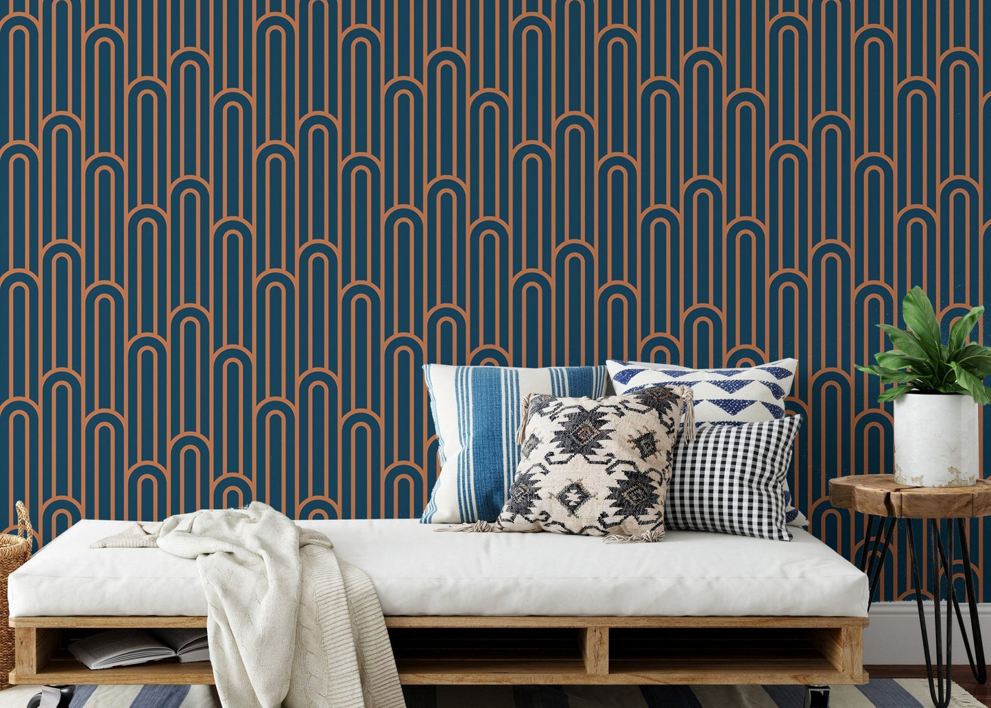 Linear Art Deco wallpaper behind a daybed with patterned blue cushions.