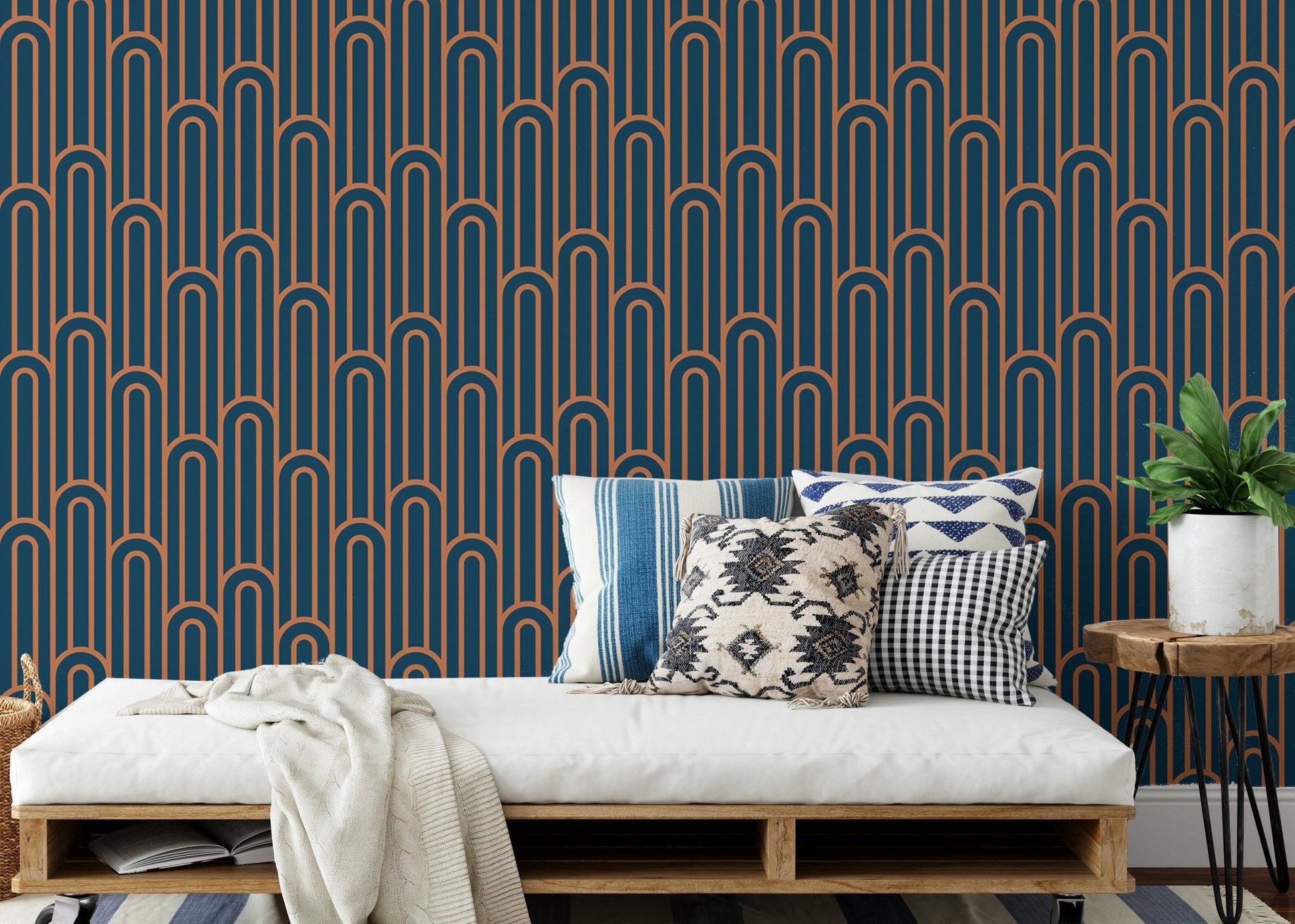 Linear Art Deco wallpaper behind a daybed with patterned blue cushions.