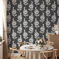 Damask pattern wallpaper in a dining space with a round wooden table.
