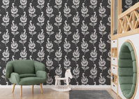 Leaf pattern wallpaper in a play area with a green chair and toy horse.