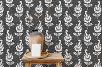 Dark damask wallpaper behind a wooden side table and clay vase.