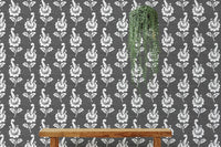 Damask leaf wallpaper on a feature wall with a wooden bench and vine.