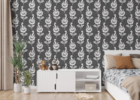 Abstract autumn leaf design black damask wallpaper in a bedroom with white unit.