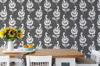 Abstract autumn leaf design black damask wallpaper behind wooden dining table.
