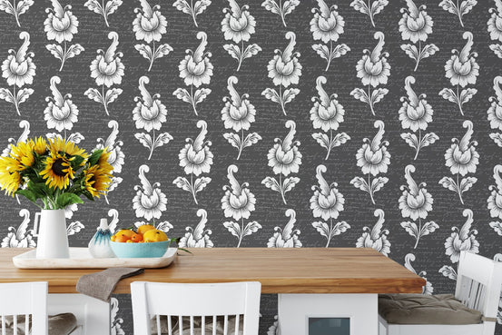 Abstract autumn leaf design black damask wallpaper behind wooden dining table.