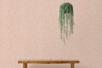 Beige and white hand-painted polka dots wallpaper and hanging plant.
