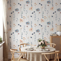 Botanical flower wallpaper behind a round dining table with wooden chairs.