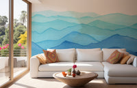 Watercolor blue waves wall mural behind a white sectional sofa