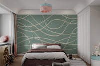 Minimalist sage green wall mural with thick intersecting wavy cream stripes.
