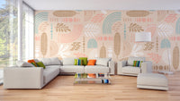 Abstract leaves and geometric shapes beige color wall mural behind a dark grey couch.