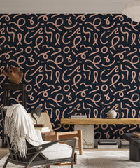 Navy blue geometric line wallpaper in a living room with a grey armchair and white rug.