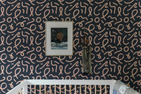 Abstract minimal line brush stroke wallpaper in a nursery with a white cot.