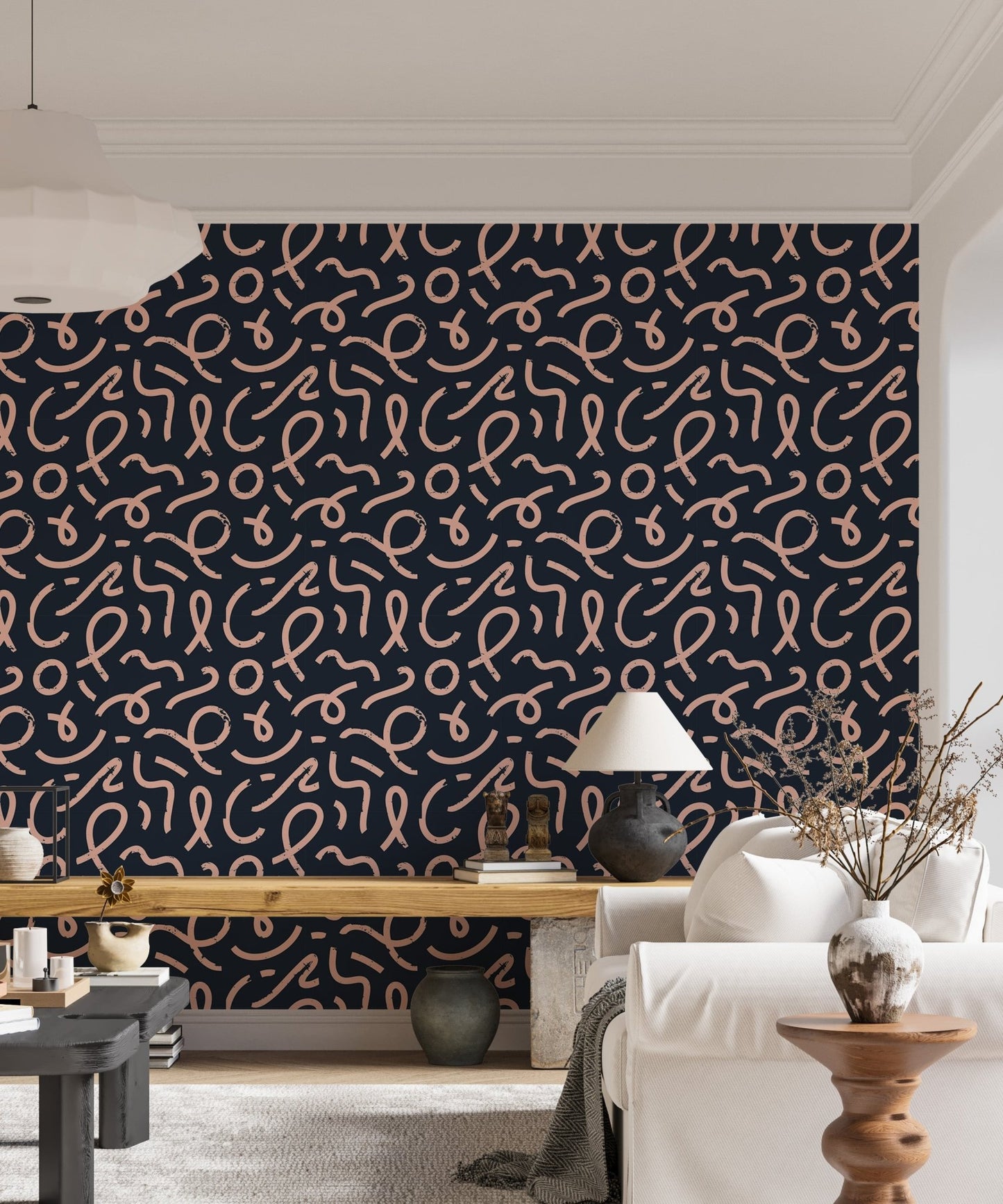 Navy blue wallpaper with pink brush strokes behind a light colored sofa.