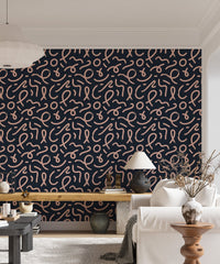Navy blue wallpaper with pink brush strokes behind a light colored sofa.