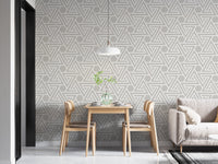 Geometric line pattern wallpaper in a dining area with wooden chairs.