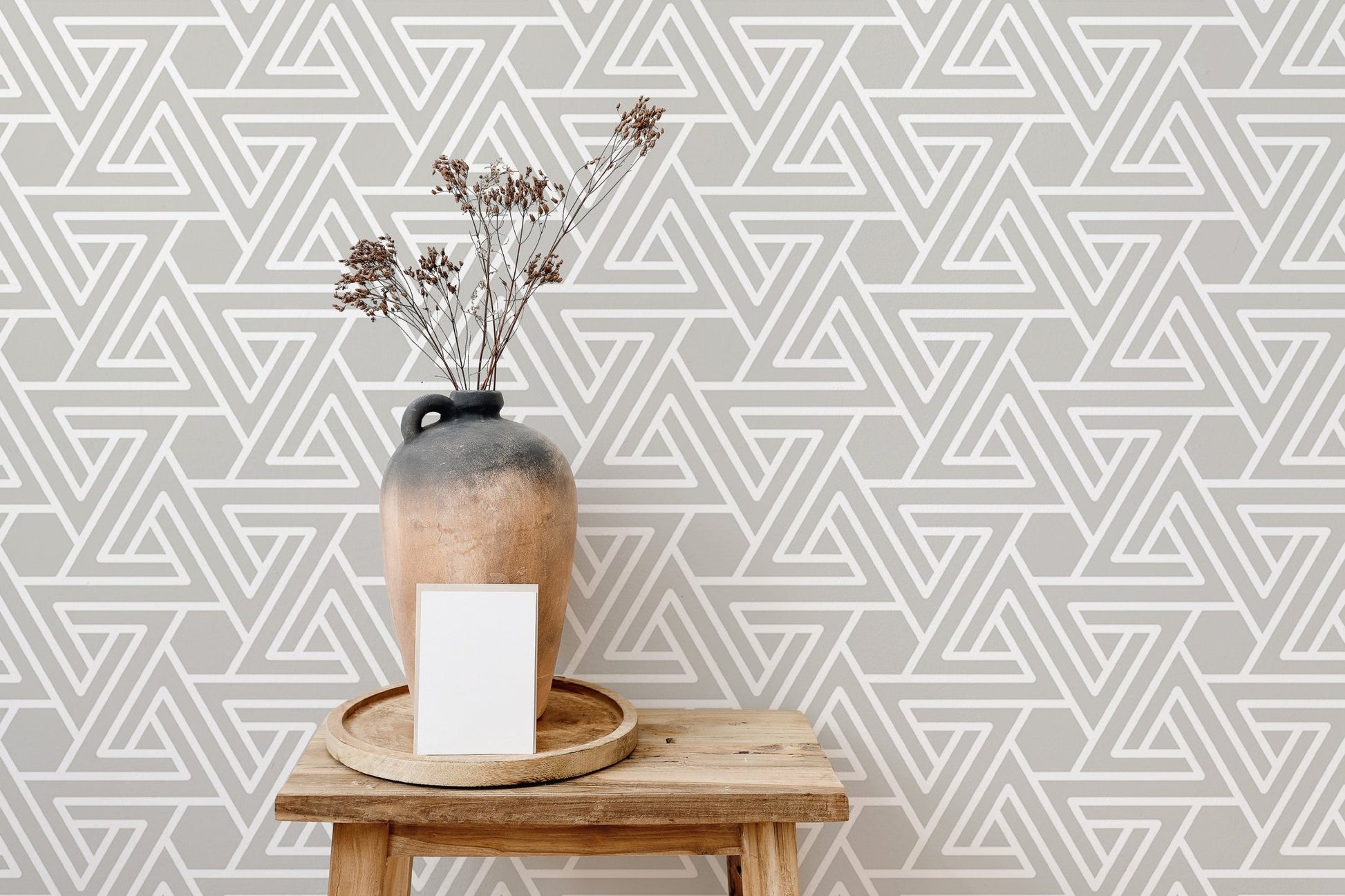 Abstract line wallpaper on a small wall with a wooden side table.