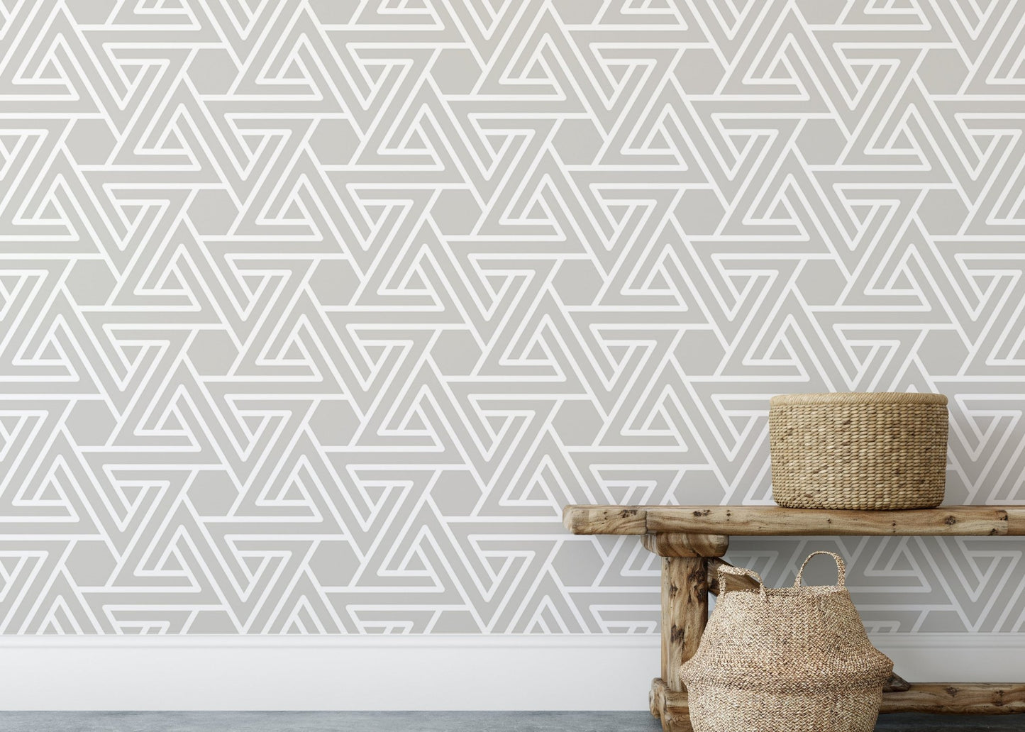 Neutral geometric wallpaper behind a wooden bench and woven baskets.