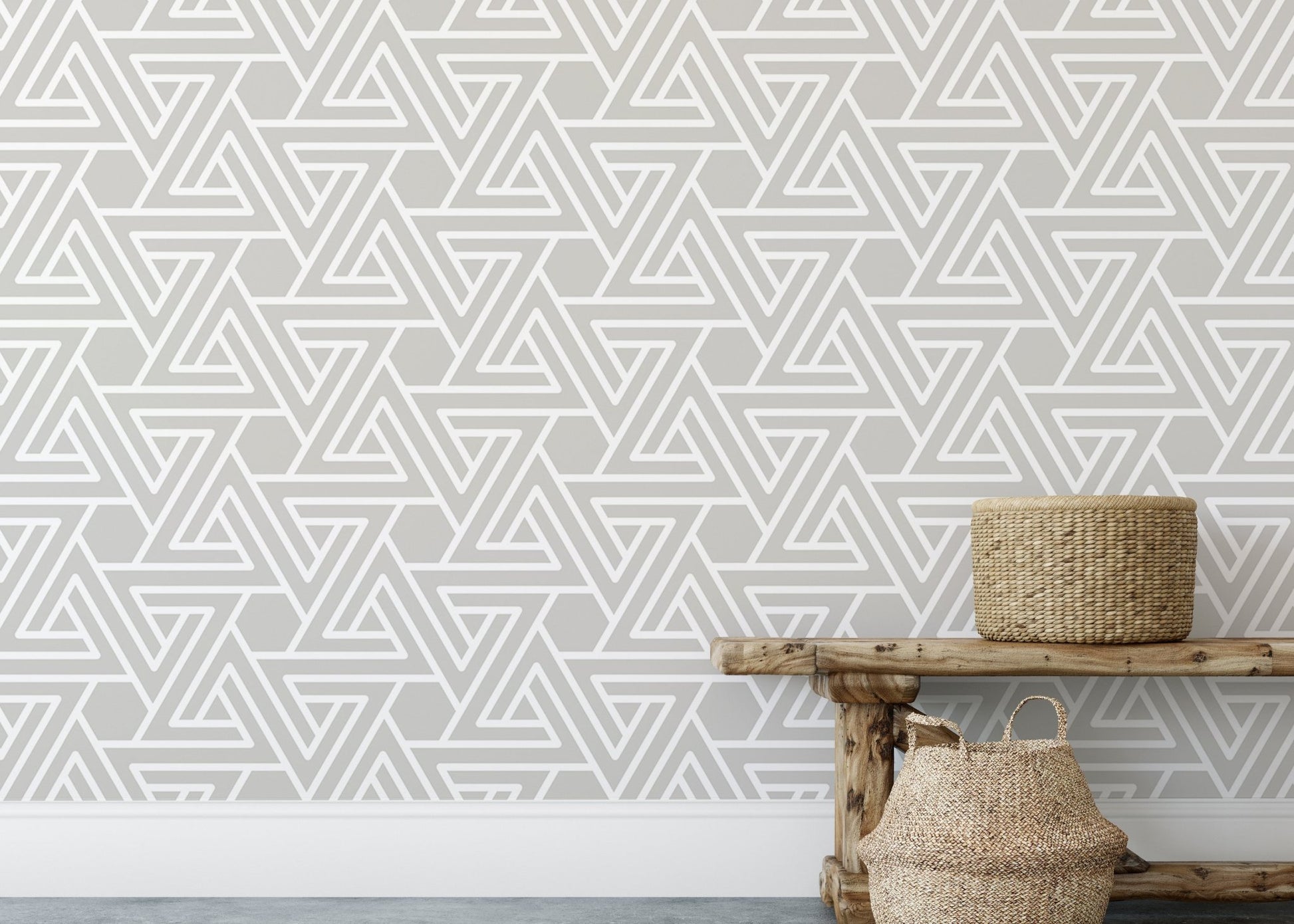 Neutral geometric wallpaper behind a wooden bench and woven baskets.
