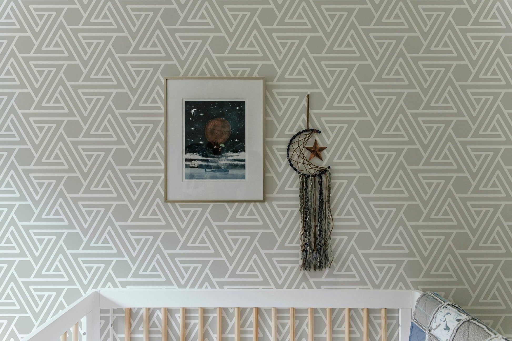 White line geometric wallpaper in a nursery with framed wall art.