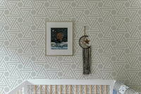 White line geometric wallpaper in a nursery with framed wall art.