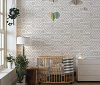 Simple line art wallpaper in a nursery with a wooden crib.