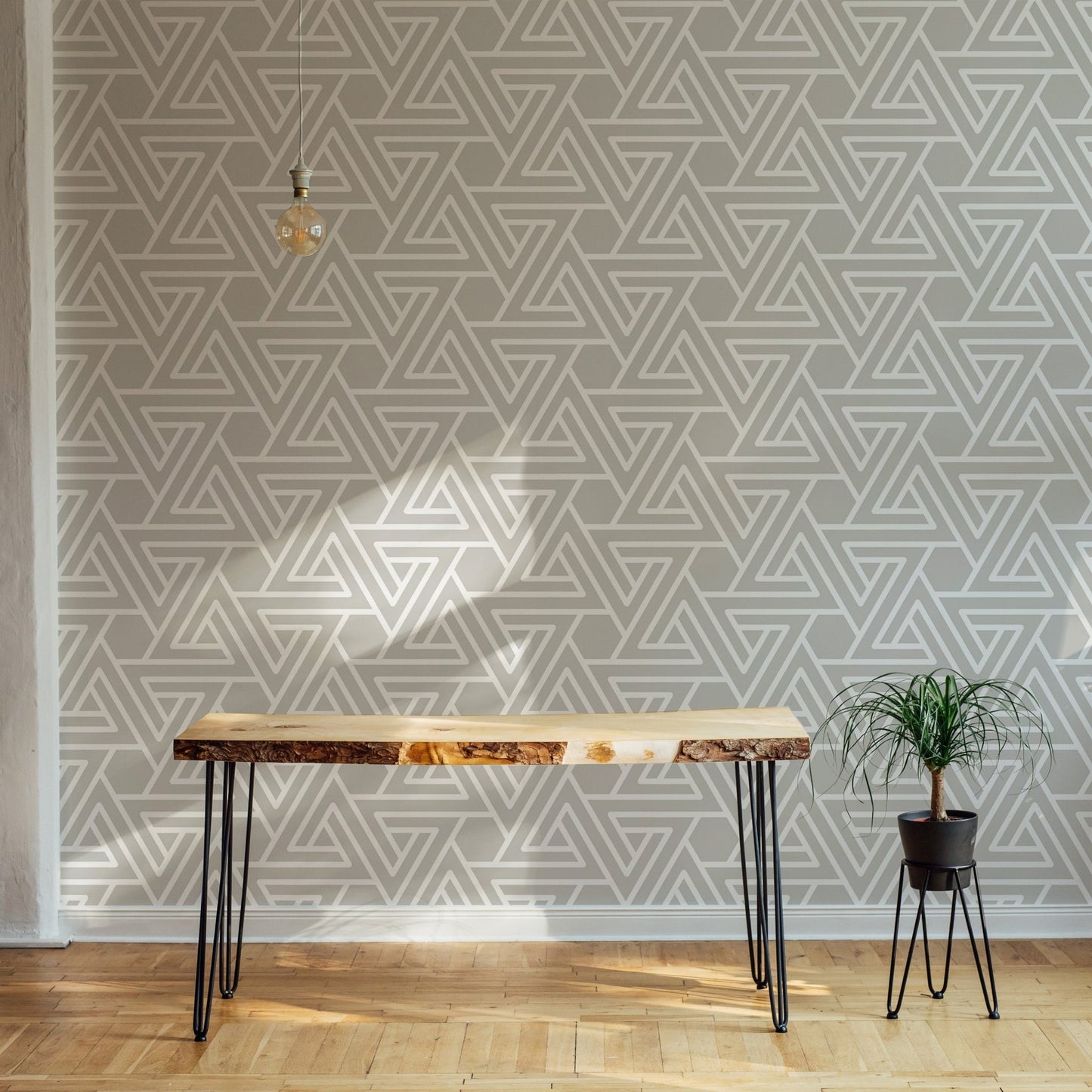 Minimalist geometric wallpaper behind a wooden desk in an office.
