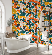 Vibrant geometric wallpaper in a bathroom behind a white freestanding tub.
