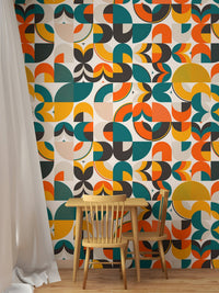 Geometric shapes wallpaper in a study nook with wooden chair and white curtains.