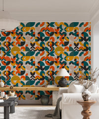 Multicolor geometric wallpaper behind a white sofa and wooden desk area.
