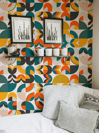 Scandi art wallpaper in a bedroom area with grey cushions and black frames.