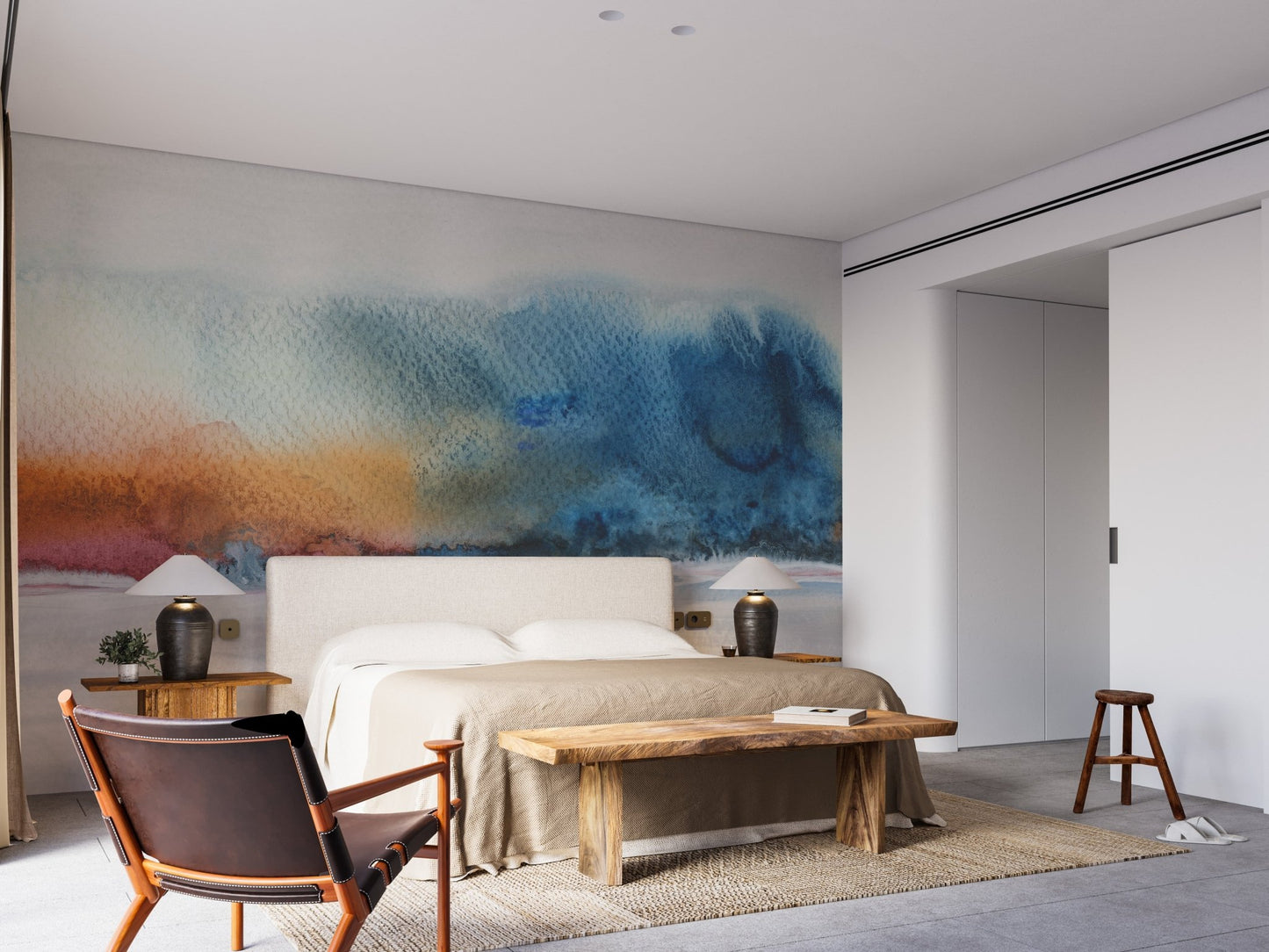 Bedroom interior with blue watercolor wall mural behind a king-size bed.